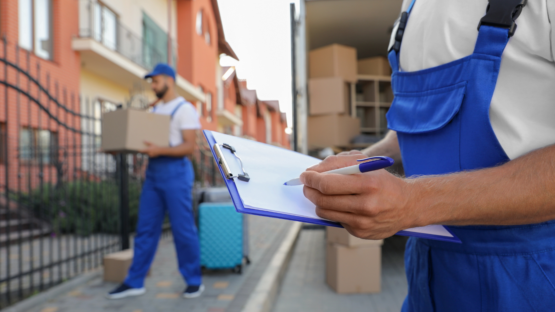Moving Service working outdoors unloading boxes and checking list