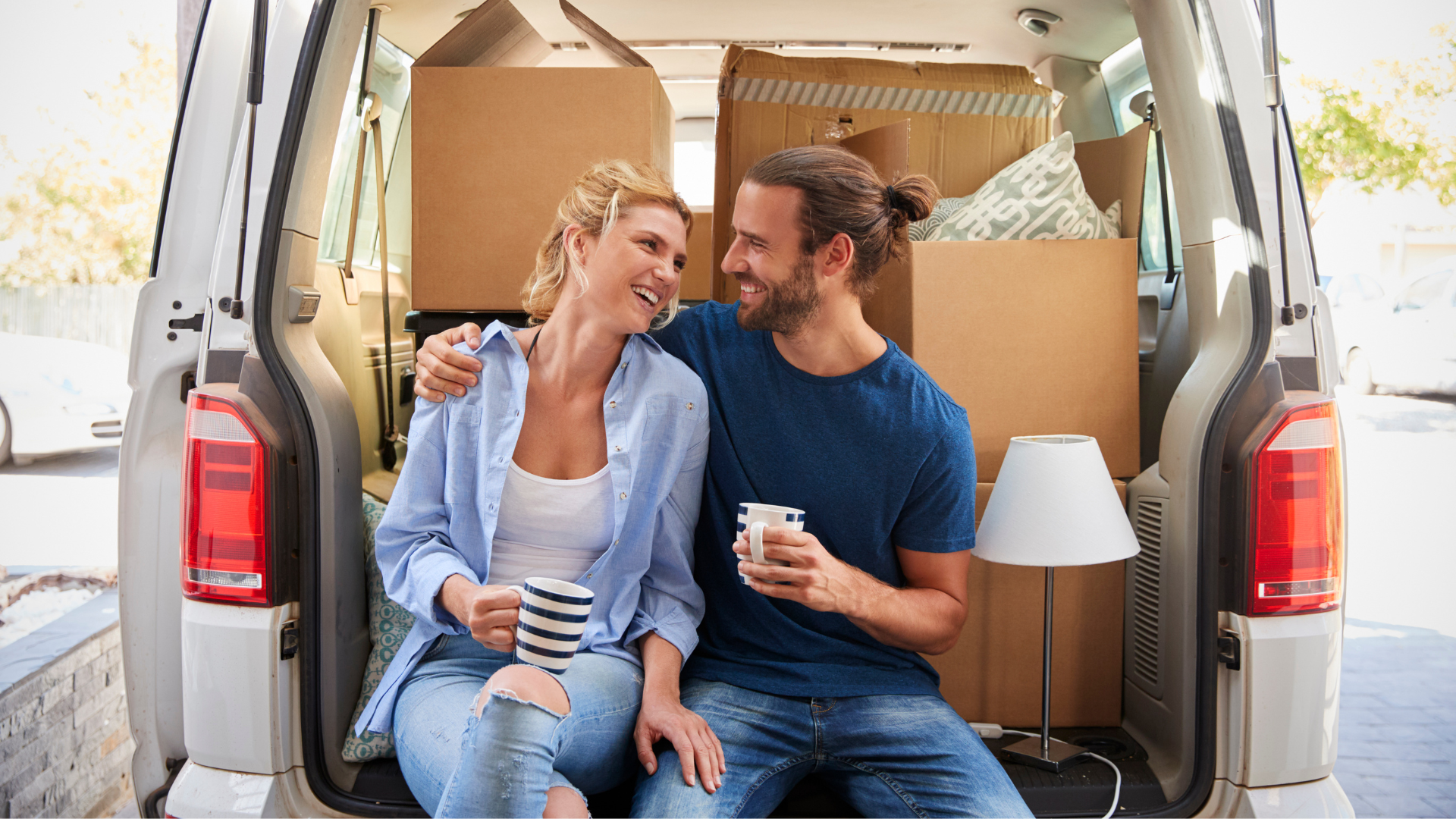 Couple taking a break at the back of moving truck on moving day