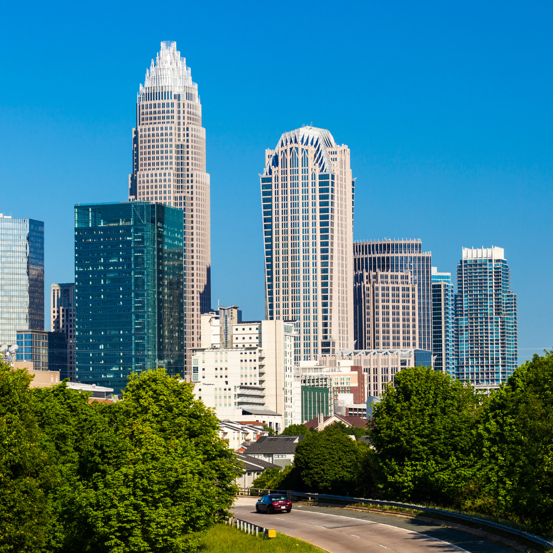 Skyline of Charlotte, NC, displaying a variety of tall buildings against a clear sky