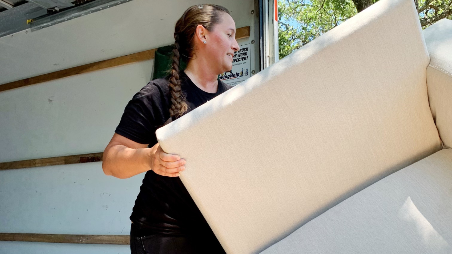 Caddy woman mover moving a big size couch into a moving truck out of a storage unit.