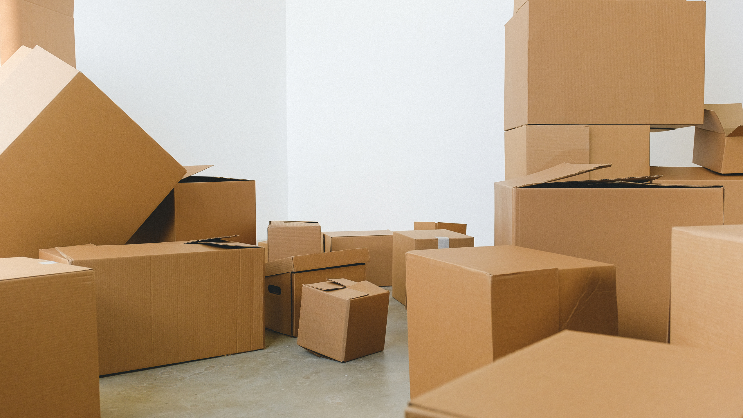 Brown moving boxes stacked in a white room