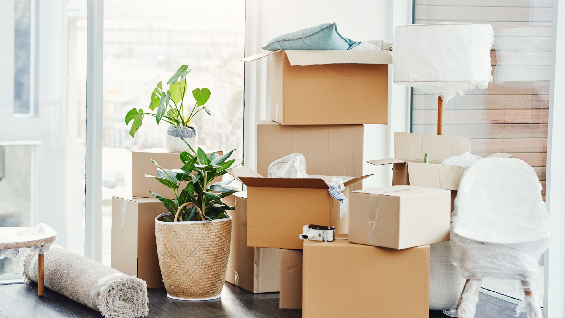 <img src=“Living room with moving boxes.png” alt=“packed moving boxes in living room”>