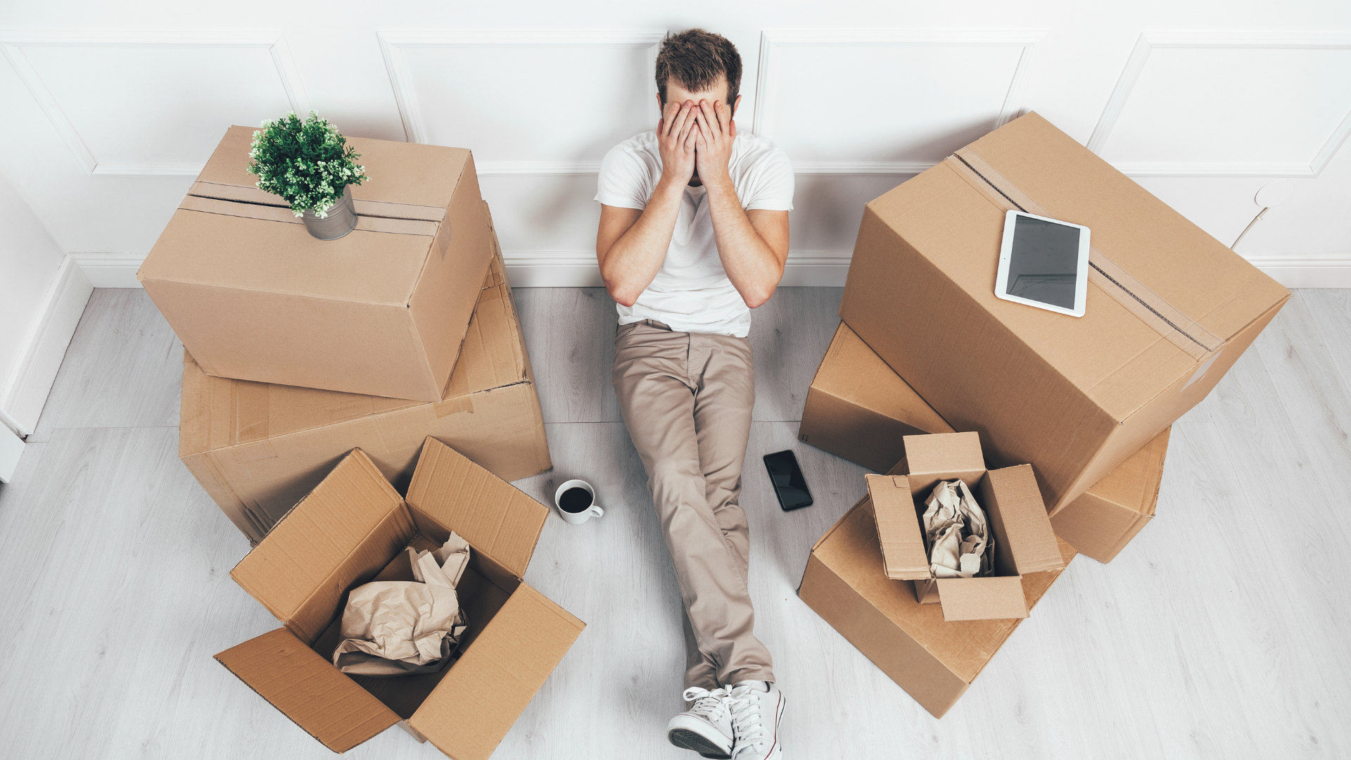 This man surrounded by his stuff before doing the move is covering his face as sign of being worries