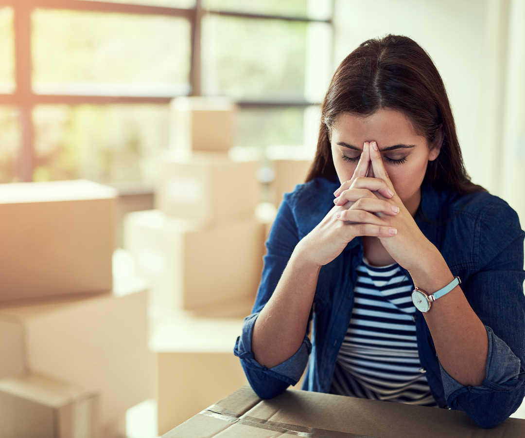 <img src=“woman stressed moving.png” alt=“woman stressed with moving boxes in the background”>