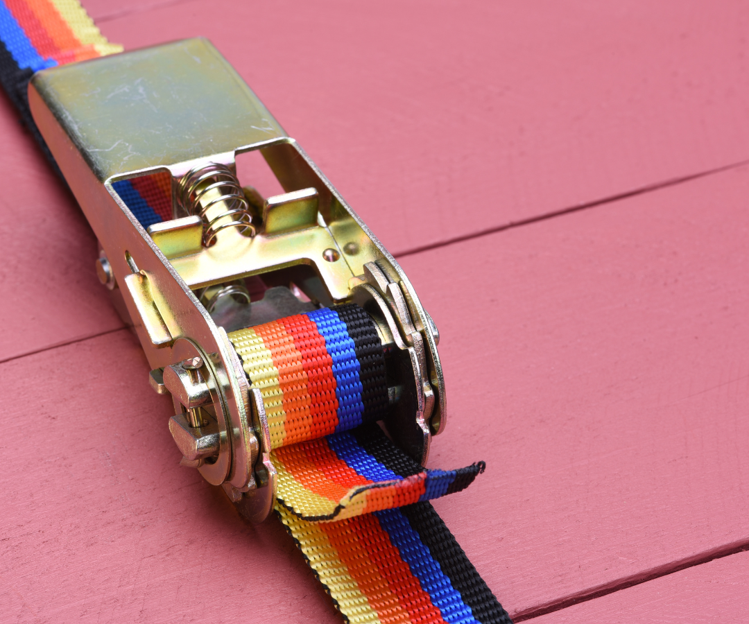 <img src=“ratchet strap.png” alt=“ratchet strap on wood board”>