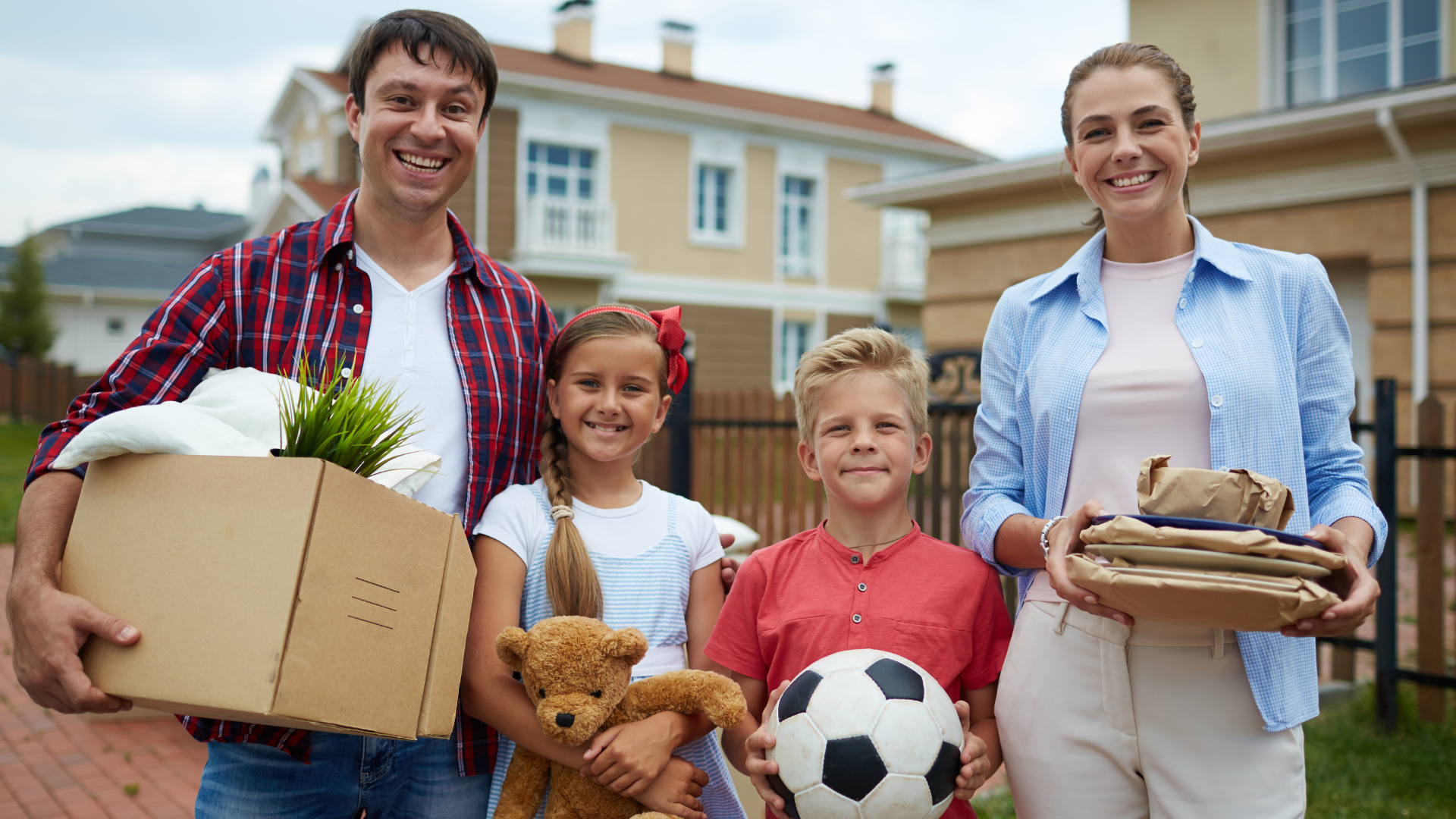 Happy family moving into their new home carrying box and kids carrying their toys