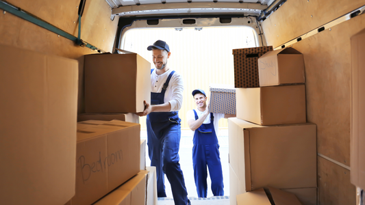 Movers unloading moving boxes to car