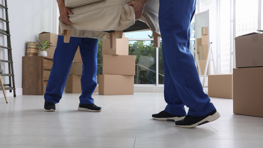 2 movers using their muscles to move a heavy furniture and all the stuff that need to be moved 