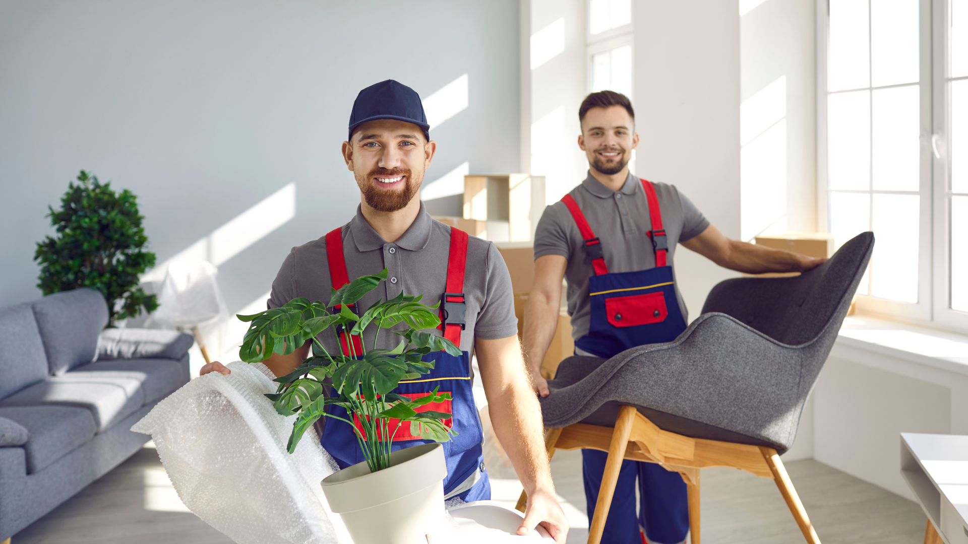 2 movers carrying heavy furniture and happily moving out items out of the unit 
