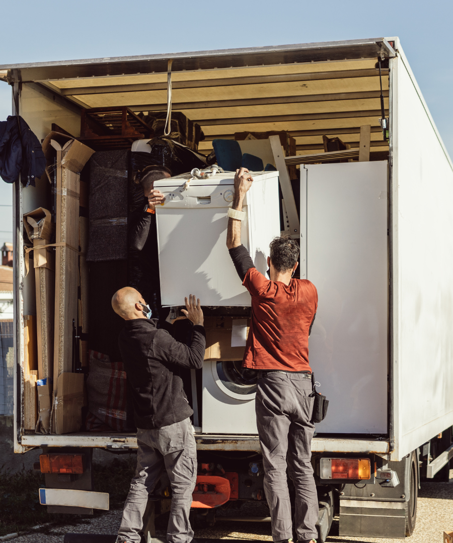 alt="3 men's lifting heavy appliances"