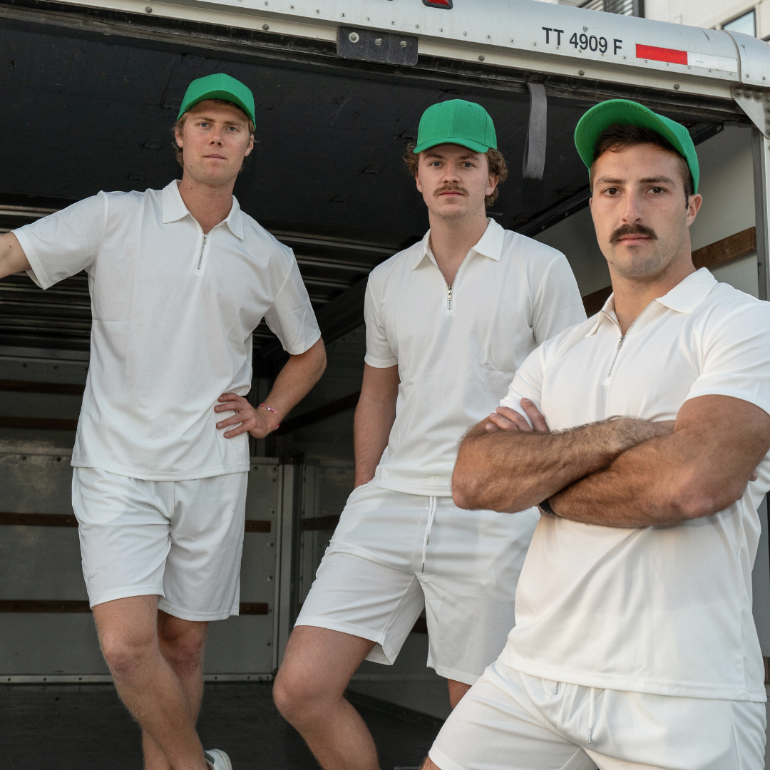 alt="three professional movers standing on the lift bed of a uhaul truck with a serious gaze"